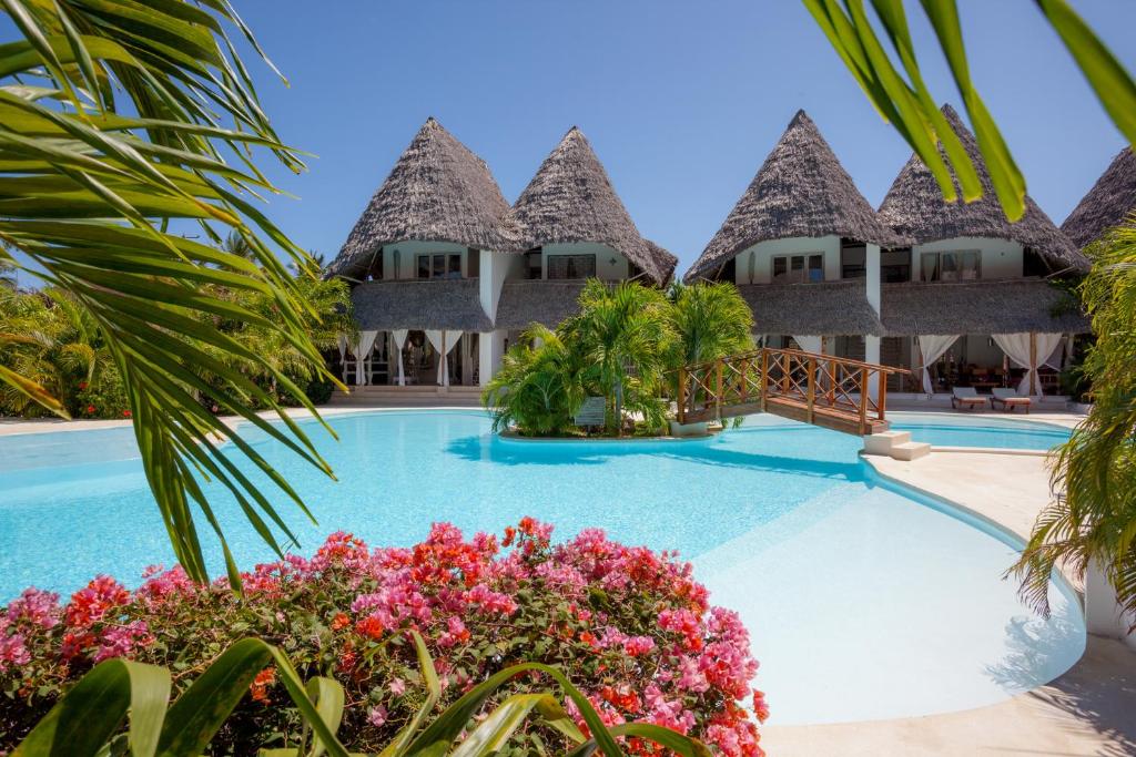 a resort with a swimming pool and some flowers at Swordfish Villas in Malindi