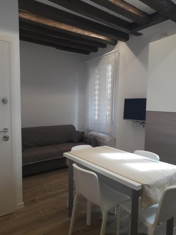 salon ze stołem, krzesłami i kanapą w obiekcie raggio di sole dietro piazza San Marco w Wenecji