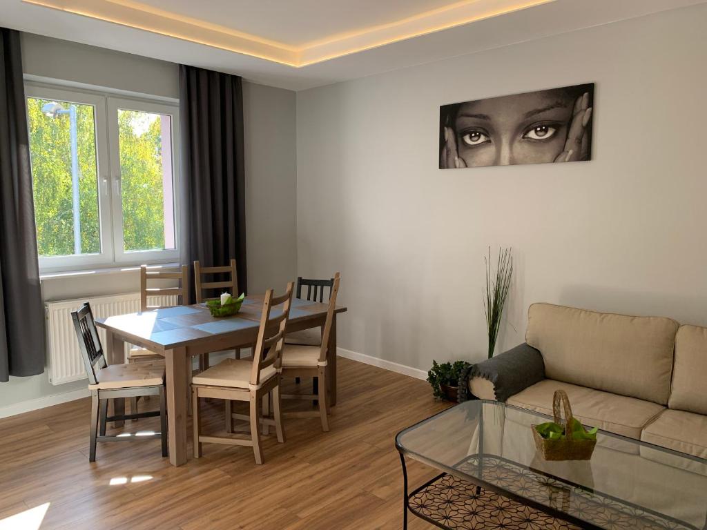 a living room with a couch and a table at Grey apartment 50 m2 in Tarnowskie Góry