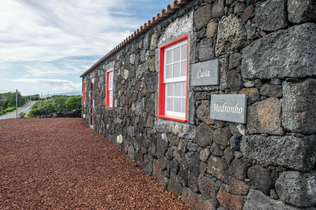 una pared de piedra con una ventana y una señal en ella en Casa Medronho en São Mateus