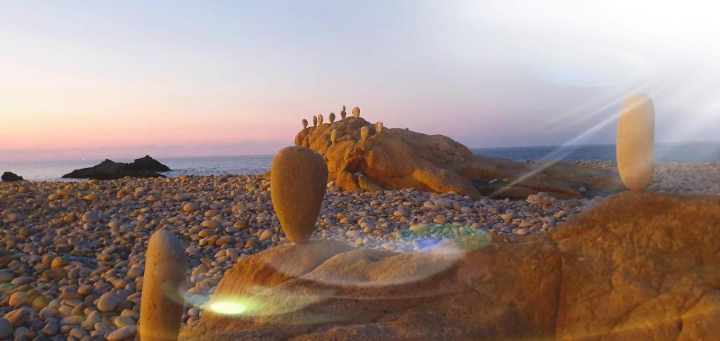 een groep mensen die op een rots op een strand staan bij Luna Rossa in Castel di Tusa