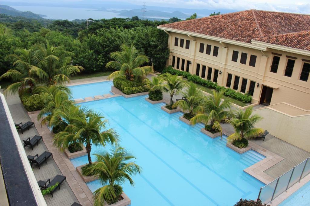widok na duży basen z palmami w obiekcie Splendido Spectacular Sky View Tower w mieście Tagaytay