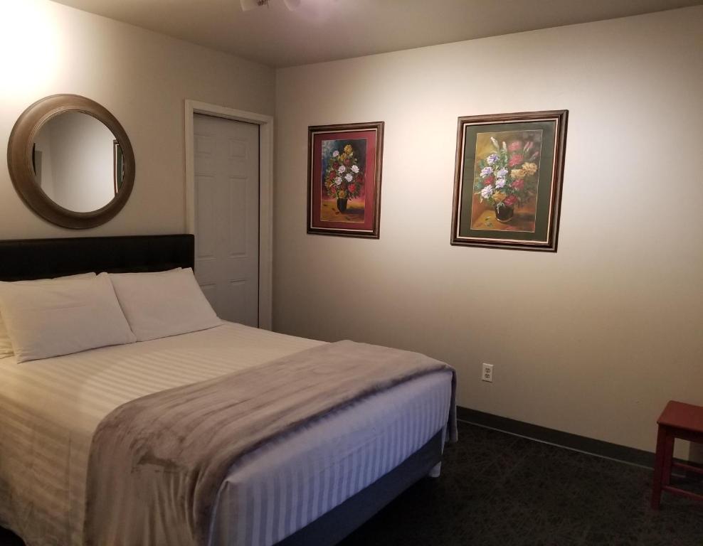 sypialnia z łóżkiem i 2 zdjęciami na ścianie w obiekcie Deep Water Inn w mieście Chelan