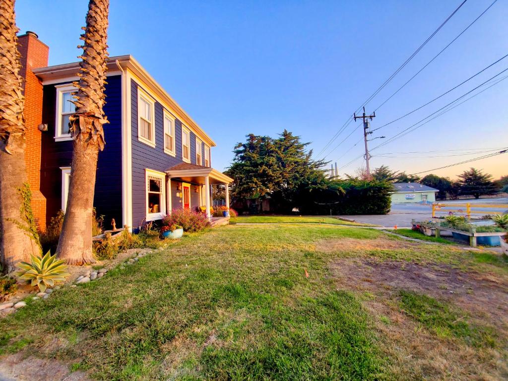 a house with a palm tree in the yard at Captain's Inn at Moss Landing in Moss Landing
