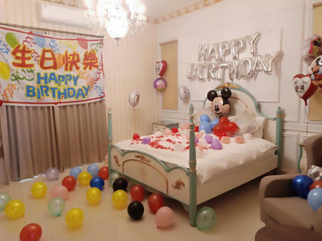 吉安的住宿－卡諾瓦民宿 ，一间设有一张带生日快乐标志和气球的床的房间