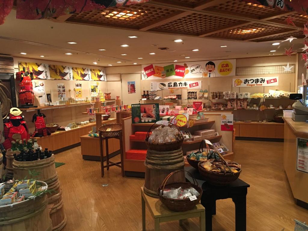 a store with a grocery store with tables and baskets at Miyajima Morinoyado in Miyajima