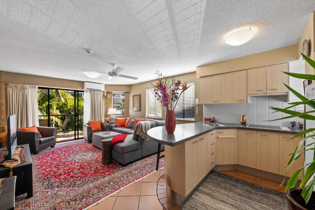 an open kitchen and living room with a couch at Asiatic Suite at Nautilus Mooloolaba in Mooloolaba