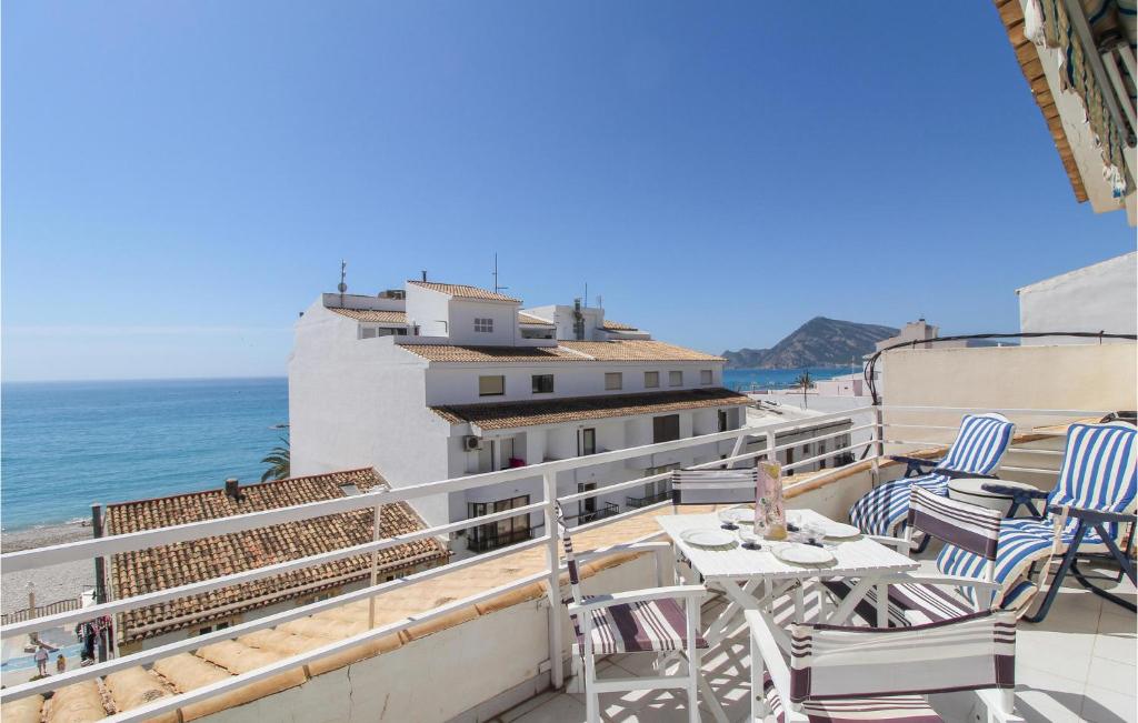 balcone con sedie, tavolo e vista sull'oceano di Amazing Apartment In Altea With Kitchen ad Altea