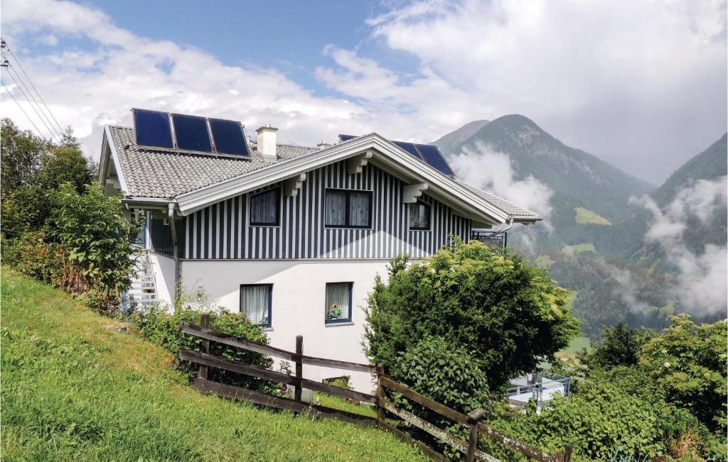 une maison avec des panneaux solaires au sommet d'une colline dans l'établissement Ferienwohnung Hohe Tauern, à Mörtschach