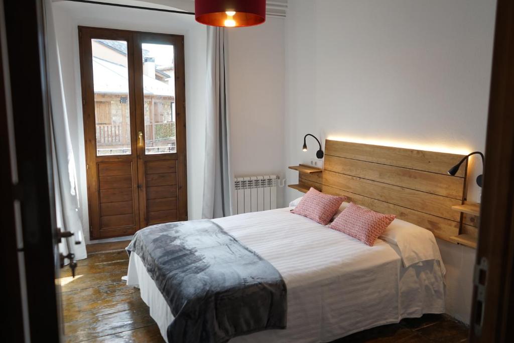 a bedroom with a large bed with a wooden headboard at Fonda Biayna in Bellver de Cerdanya 