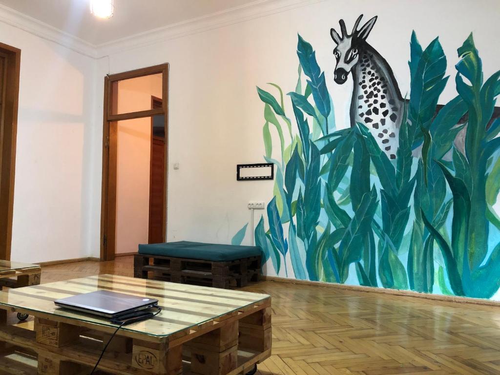 une chambre avec une peinture d'une girafe sur le mur dans l'établissement Vac Hostel, à Tbilissi