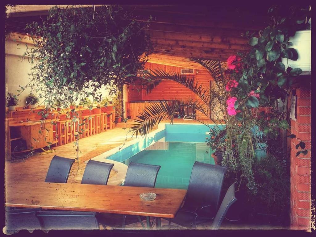 - une piscine dans une pièce avec des chaises et une table dans l'établissement DNT HOUSE & Spa, à Cîrcea