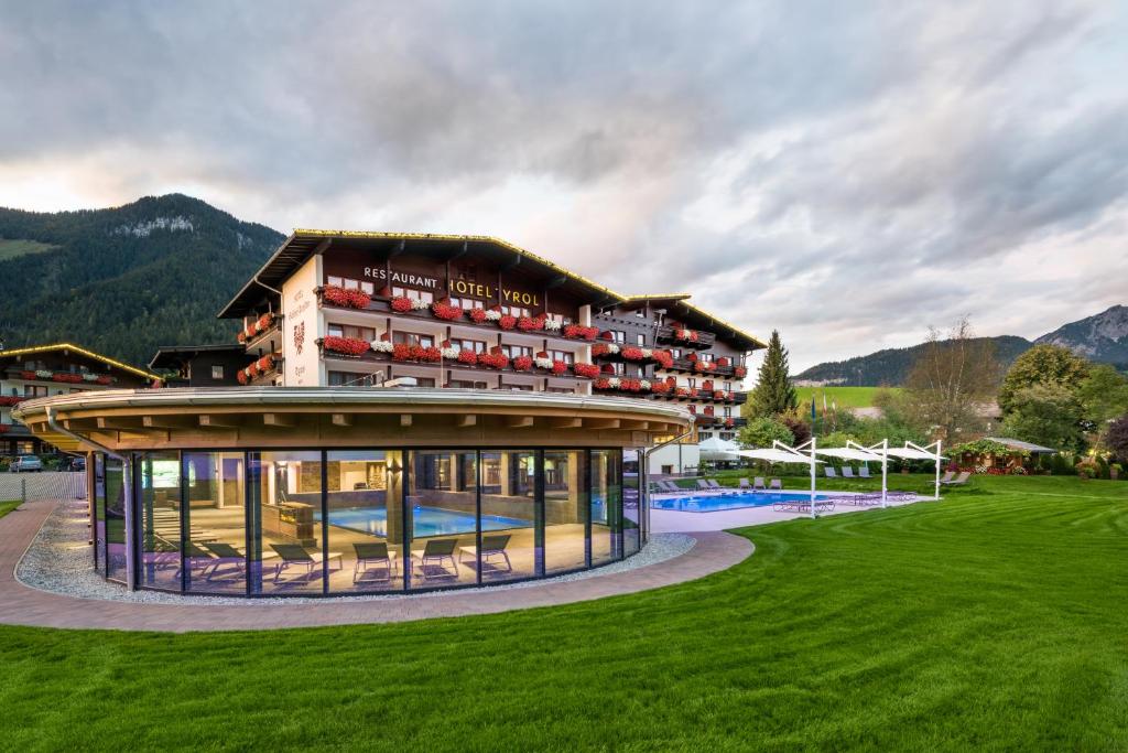 - un grand bâtiment avec une piscine en face dans l'établissement Ferienhotel Tyrol Söll am Wilden Kaiser, à Söll