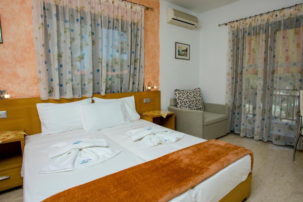 メタモルフォシにあるMaik Apartmentsのベッドと椅子付きのホテルルーム