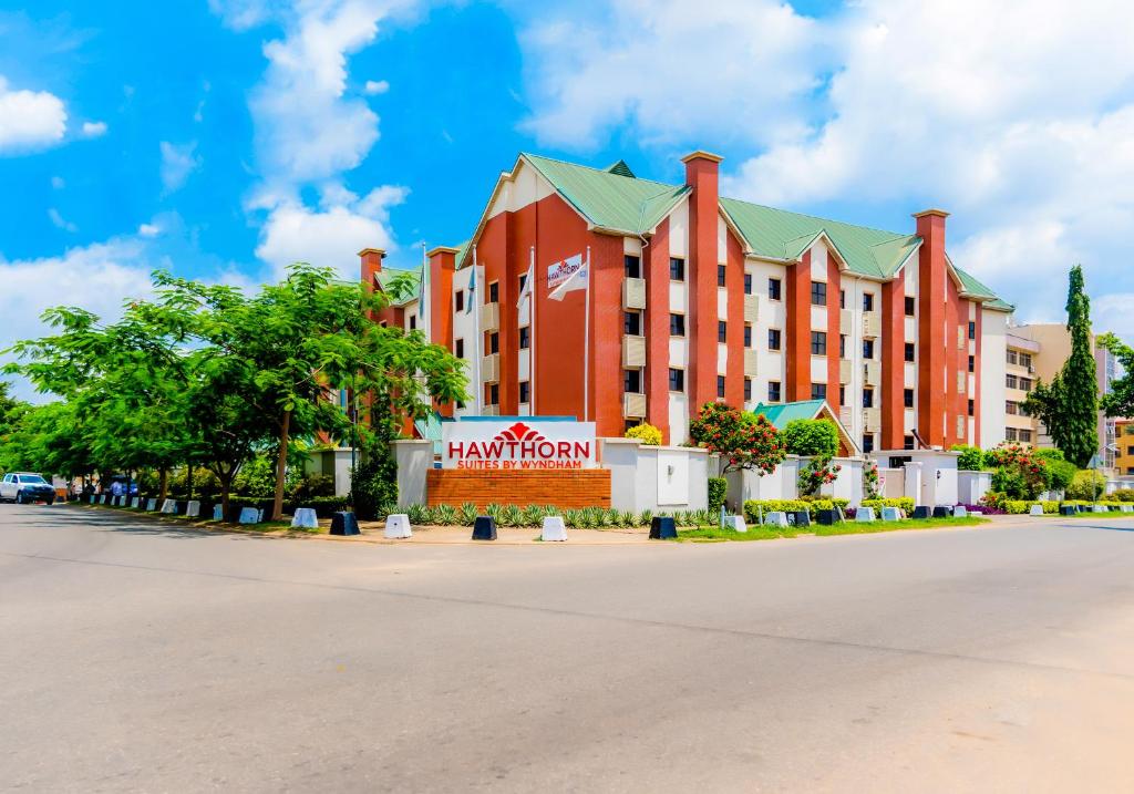 a large red building on the side of a street at Hawthorn Suites by Wyndham Abuja in Abuja