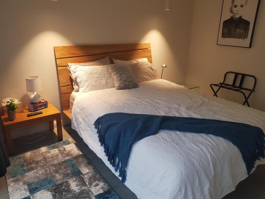 Un dormitorio con una cama con una manta azul. en Modern, private and close to town. en Albury