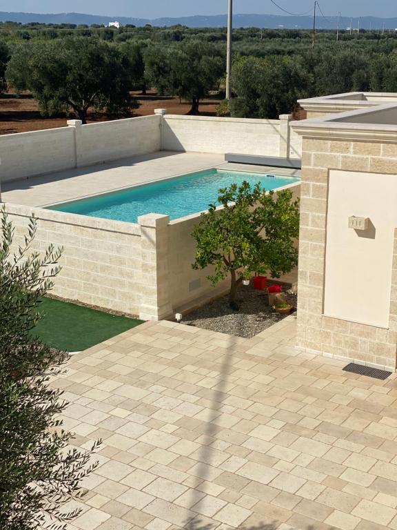 una piscina en una pared de ladrillo junto a un patio en Le Terrazze Miramare B&B, en Torre Canne