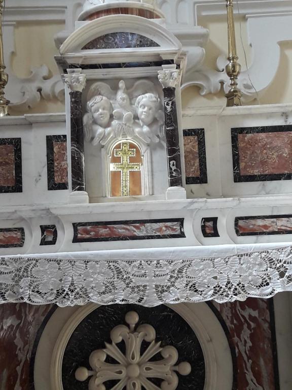 een kerk met een wit altaar met een kruis bij b&b Tosches in Barletta