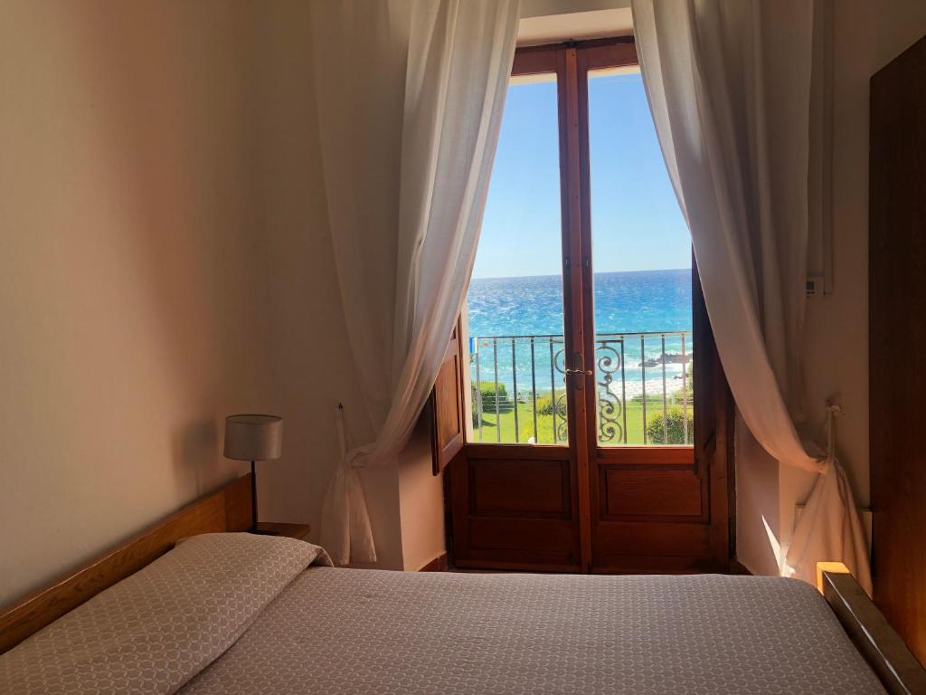 a bedroom with a bed and a view of the ocean at hotel Ducale in Diamante