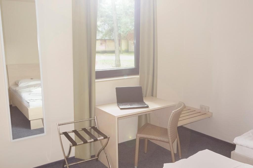 a white desk with a laptop on it in a room at Best Deal Airporthotel Weeze in Weeze
