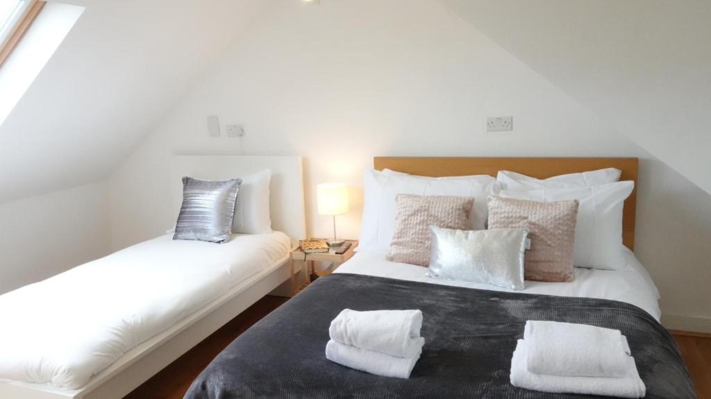 sypialnia z 2 łóżkami i białymi poduszkami w obiekcie Great Airport Sleep w mieście Harmondsworth