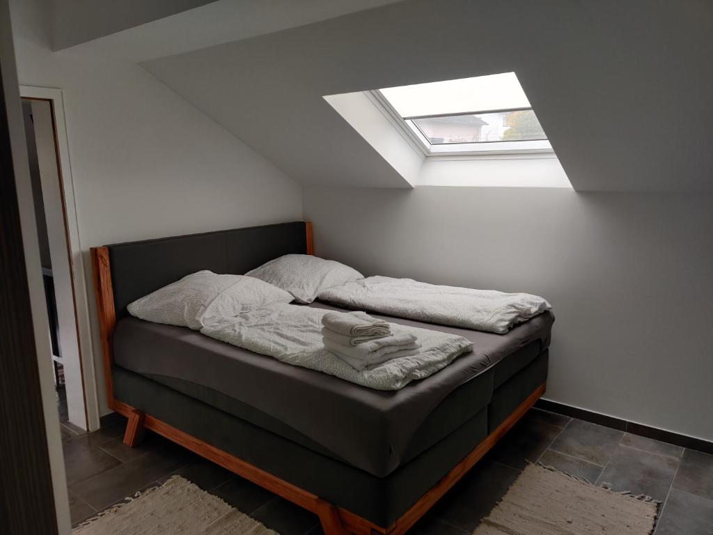 ein kleines Bett in einem Zimmer mit Dachfenster in der Unterkunft Im Mückenberg 4 in Lahnstein