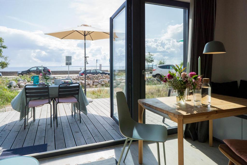 - une salle à manger avec une table et une vue sur l'océan dans l'établissement Ferienwohnung "Heiterer Hering", à Sierksdorf