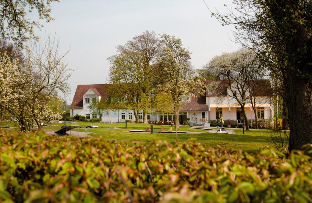 ein großes weißes Haus mit einem Baum davor in der Unterkunft Landgasthof Pleister Mühle in Münster