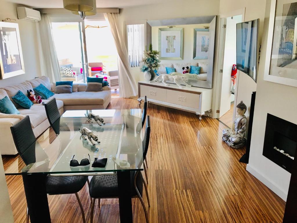 a living room with a glass table and a couch at Luxury Apartament in Marina in Benalmádena