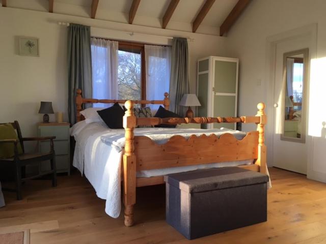 sypialnia z dużym łóżkiem z drewnianą ramą w obiekcie Three Oaks Nursery w mieście Chichester