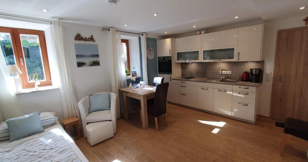 a kitchen with a table and a dining room at Ferienwohnung 1 Rinser mittig in Vogtareuth in Vogtareuth