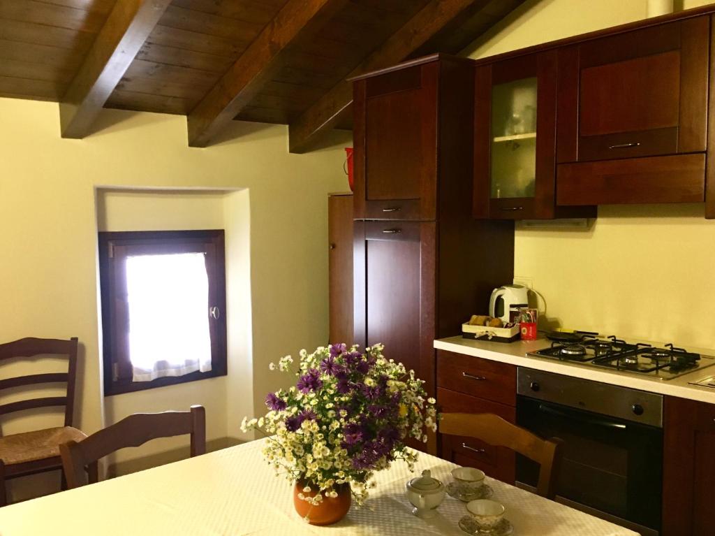 a kitchen with a table with flowers on it at Antico Borgo dell'Anconella - grande appartamento rustico in Anconella