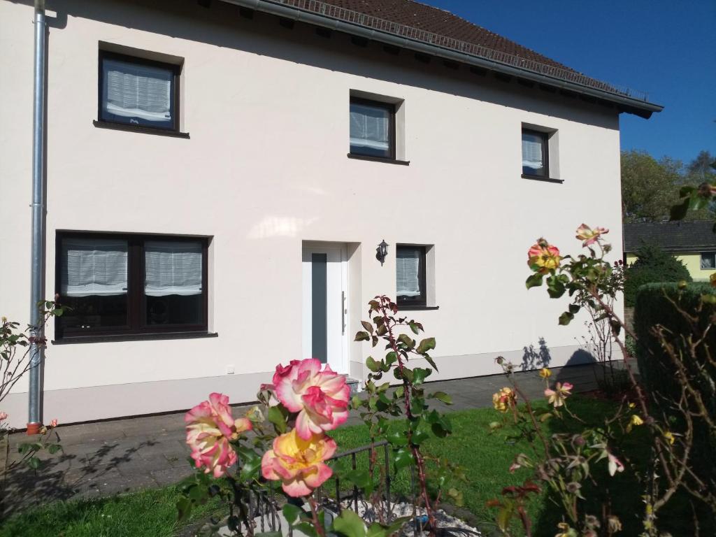 a white house with flowers in front of it at Zum Rosenhügel in Hellenthal