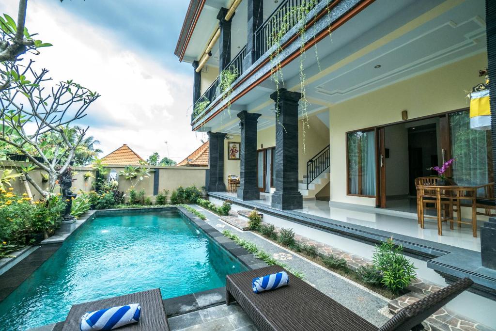 a swimming pool in the backyard of a house at Saputra Guesthouse in Ubud