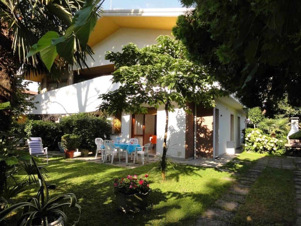 un giardino con tavolo e sedie nel cortile di Villa Galasso a Bibione