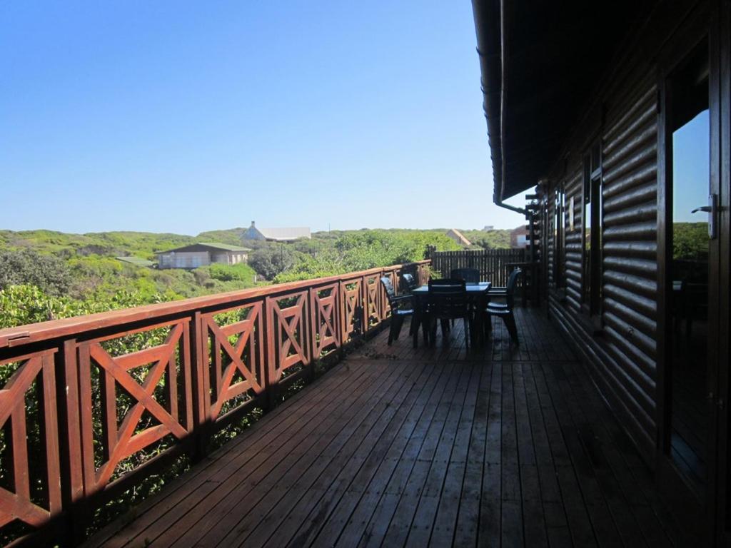 a wooden deck with a table on a bridge at CHARMING BEACH BUNGALOW in Cape St Francis