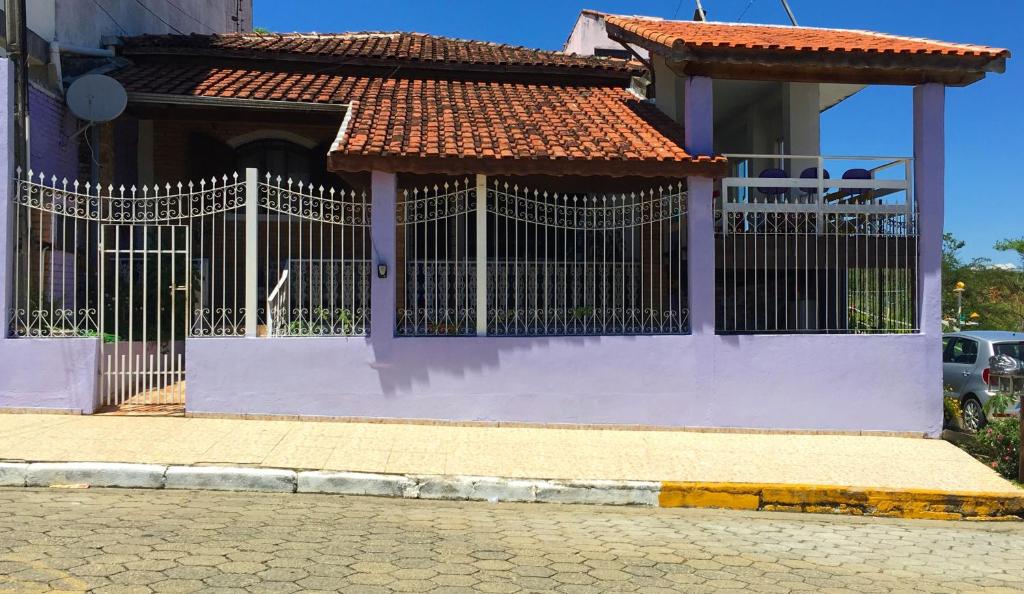 a white house with a gate in front of it at Pousada Primavera in Cachoeira Paulista