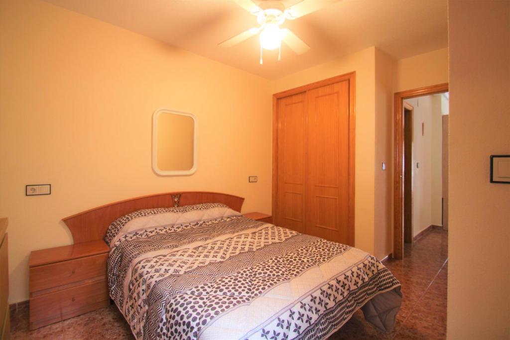 een slaapkamer met een bed en een plafondventilator bij Apartamento CasaTuris Urb.Altomar Gran Alacant GA101 in Gran Alacant