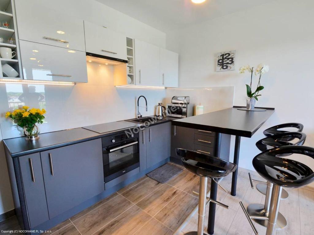 a kitchen with a black counter and some stools at Presto by Housine,pl Zator in Zator