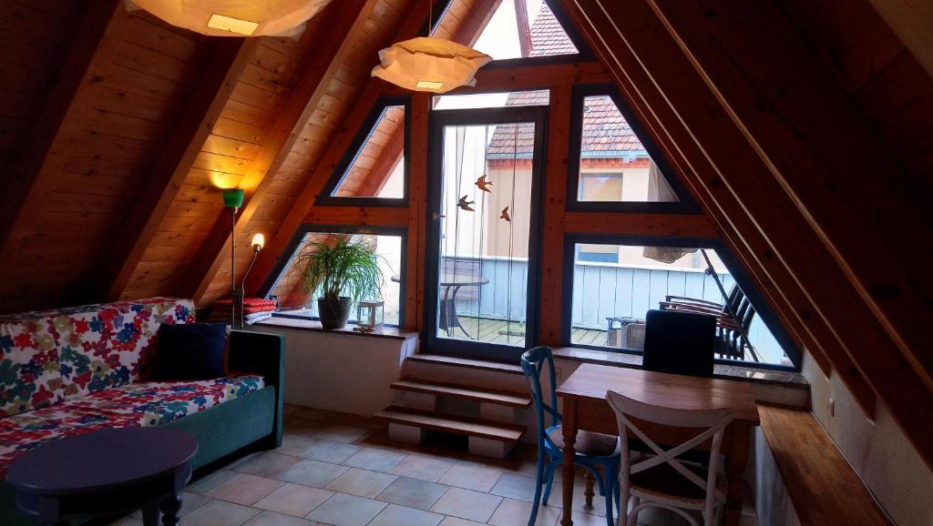 - un salon avec un canapé, une table et des fenêtres dans l'établissement Ferienhaus Nicolaus, à Radebeul