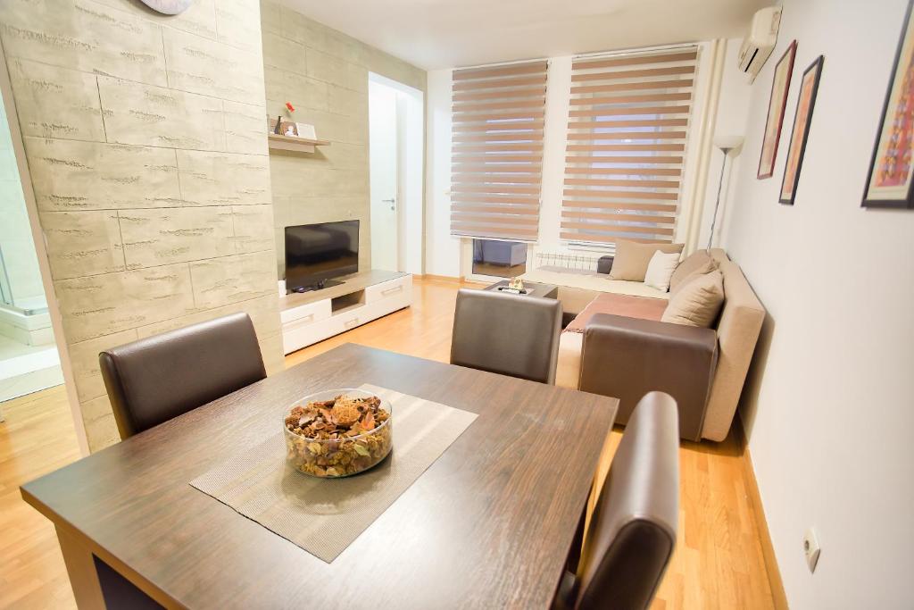 a living room with a table and chairs and a couch at Apartments Belville in Belgrade