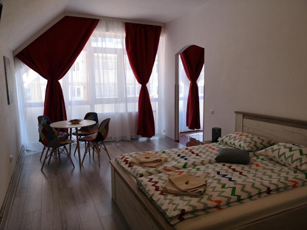 1 dormitorio con 1 cama, mesa y sillas en Mansarda Maradu, en Sinaia