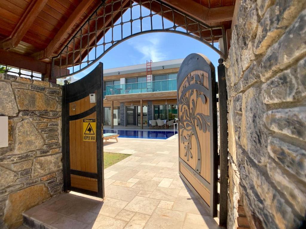 uma porta aberta para um edifício com uma parede de pedra em Ultra Luxury Private Villa with Swimming Pool em Bodrum City