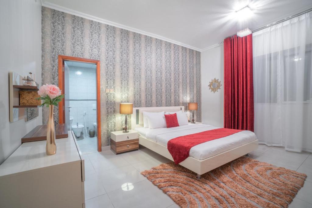 een slaapkamer met een bed en een vaas met bloemen bij A C Pearl Holiday Homes - Discover the Beauty of Marina in Dubai