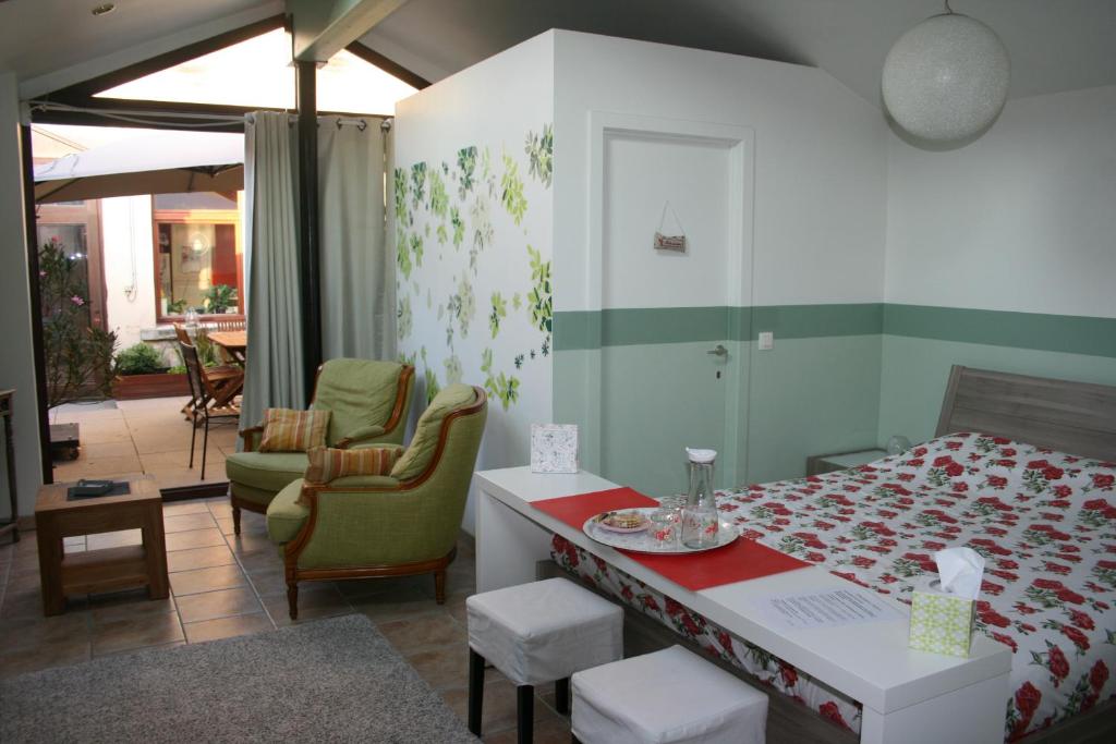 Schlafzimmer mit einem Bett, einem Tisch und Stühlen in der Unterkunft La chambre Tomis Ath in Ath