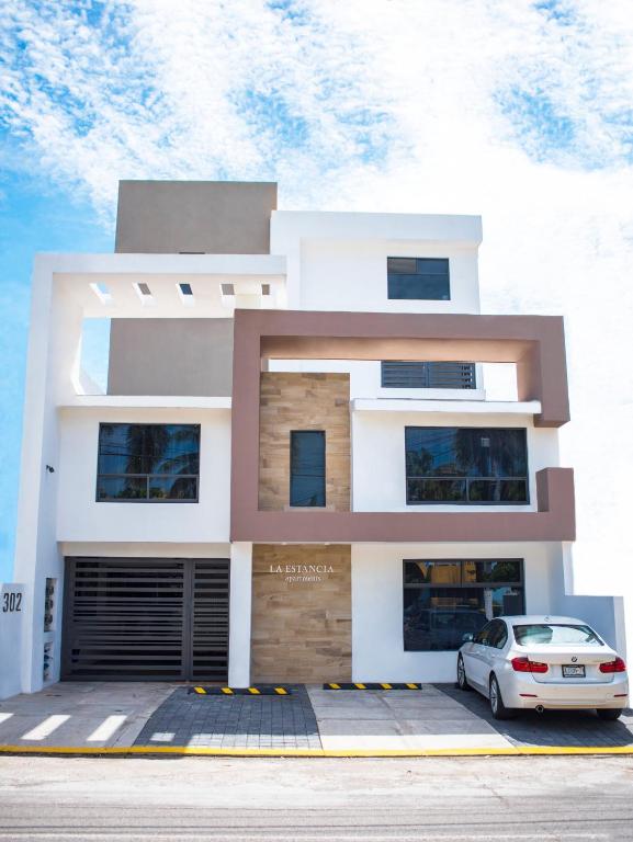 a house with a car parked in front of it at La Estancia Apartments Mazatlan in Mazatlán