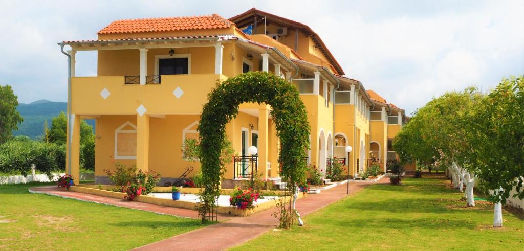 un edificio amarillo con un arco en un patio en Stars Hotel en Agios Georgios
