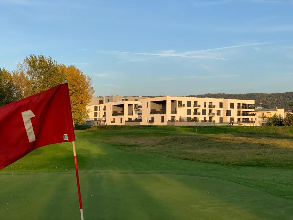 un campo de golf con bandera roja en el green en Greenbay Golf Apartments, en Trenčín