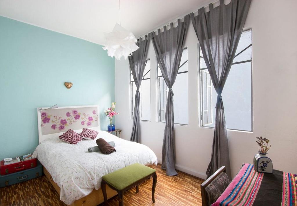 1 dormitorio con 1 cama y algunas ventanas en Casa Azul for groups since 4 till 30 persons, en Ciudad de México