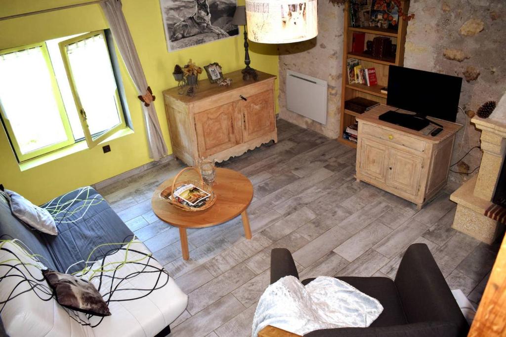 a living room with a couch and a table at La Tanière du LoupBlanc, 8mn du Zoo de Beauval in Châteauvieux